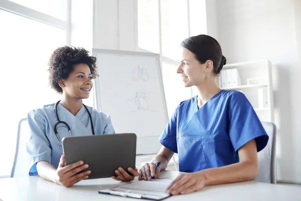 Zufriedene Ärzte mit Tablet-PC-Treffen im Krankenhaus — Stockfoto