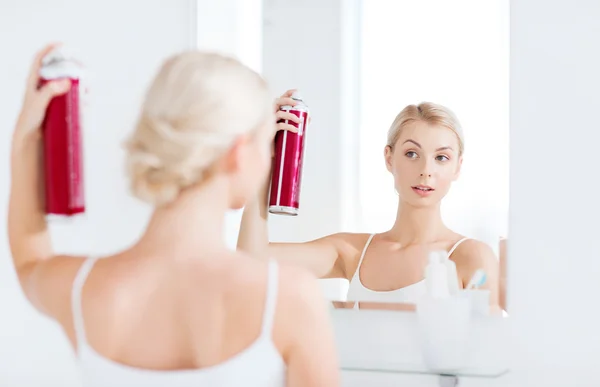 Woman with hairspray styling her hair at bathroom — Stock Photo, Image