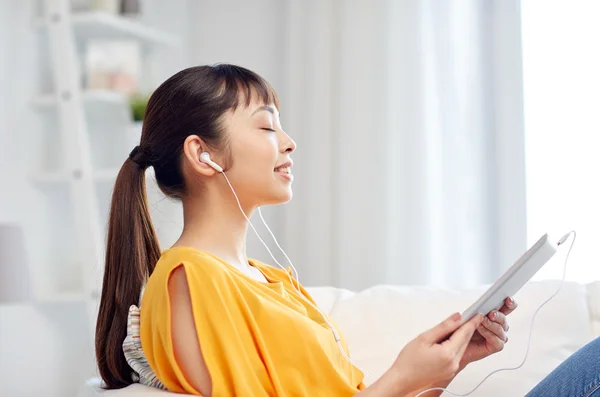 Feliz mulher asiática com tablet pc e fones de ouvido — Fotografia de Stock