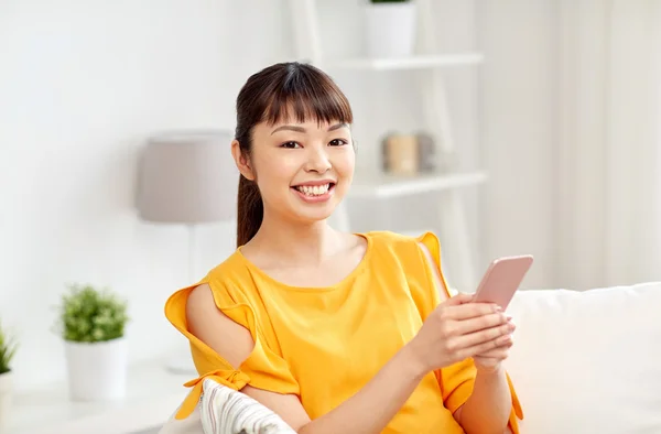 Mujer asiática feliz con smartphone en casa — Foto de Stock