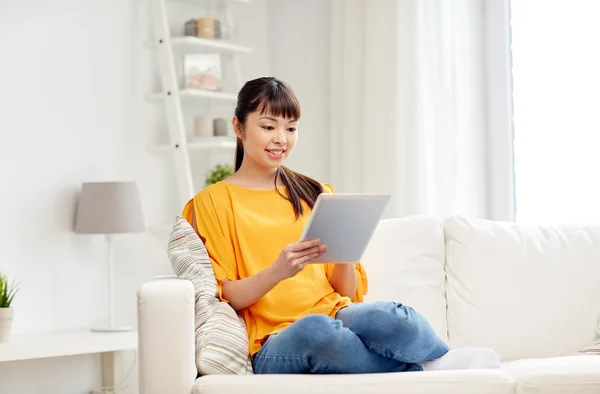 Счастливая молодая женщина с планшетным компьютером дома — стоковое фото
