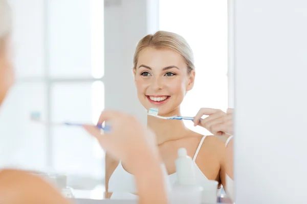 Donna con spazzolino da denti pulizia dei denti in bagno — Foto Stock