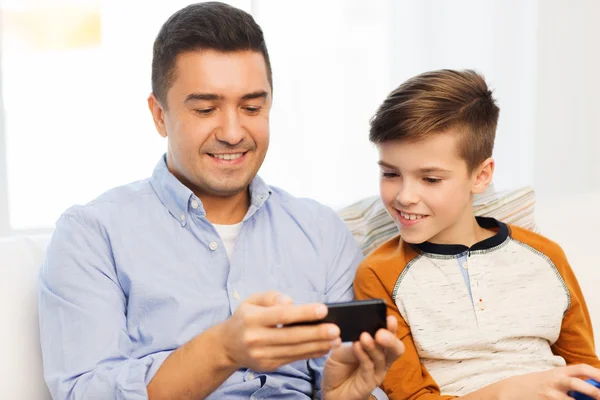 Щасливий батько і син зі смартфоном вдома — стокове фото
