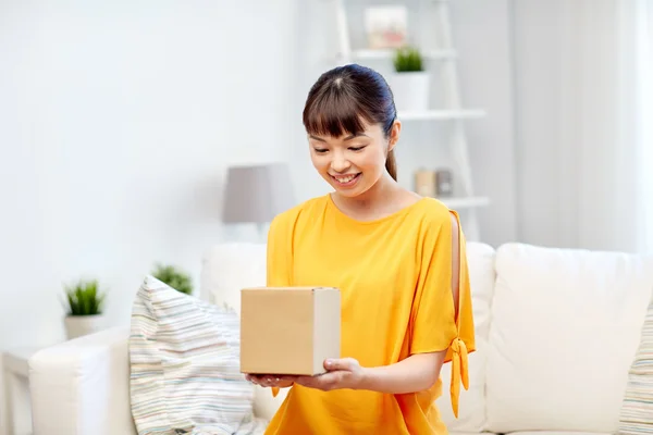 Feliz asiático joven mujer con paquete caja en casa —  Fotos de Stock