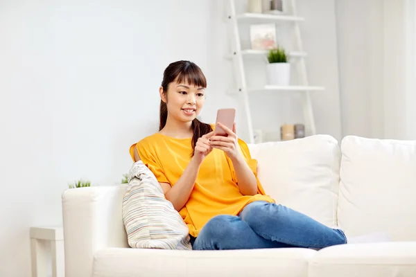 Mujer asiática feliz con smartphone en casa —  Fotos de Stock