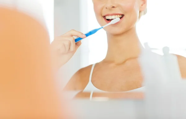 Mujer con cepillo de dientes limpieza de dientes en el baño —  Fotos de Stock