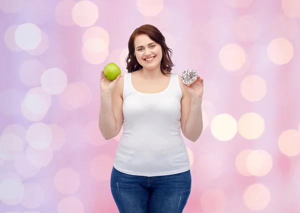 Ευτυχισμένος συν μέγεθος γυναίκα επιλέγοντας μήλο ή cookie — Φωτογραφία Αρχείου