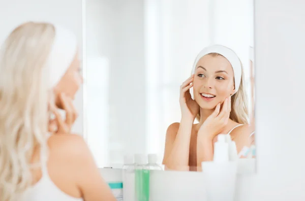 Frau mit Haarband berührt ihr Gesicht im Badezimmer — Stockfoto