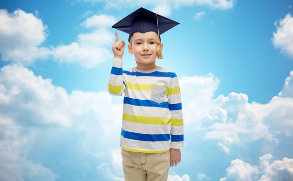 Niño feliz en sombrero de soltero señalando el dedo hacia arriba — Foto de Stock