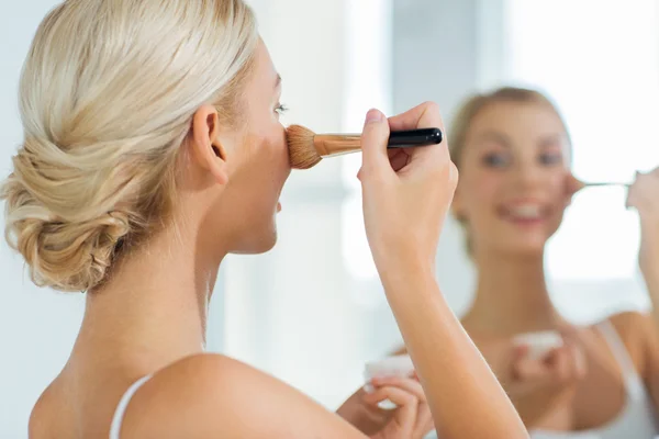 Femme avec brosse de maquillage et poudre à la salle de bain — Photo