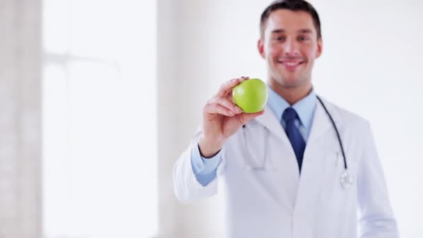 Arts met groene appel in handen — Stockvideo
