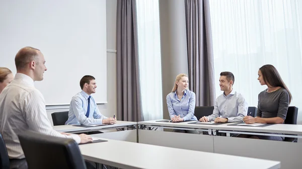 Grupo de empresários sorridentes reunidos no escritório — Fotografia de Stock