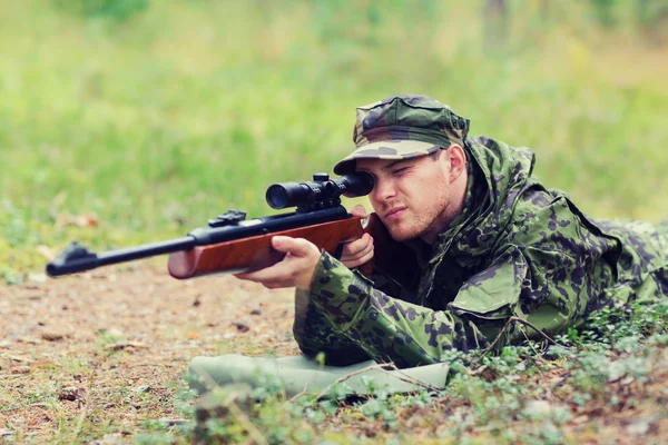 Jovem soldado ou caçador com arma na floresta — Fotografia de Stock