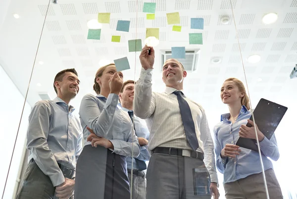 Smiling business people with marker and stickers — Stock Photo, Image