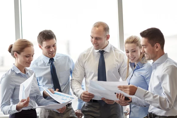 Happy affärsmän med papper talkig i office — Stockfoto