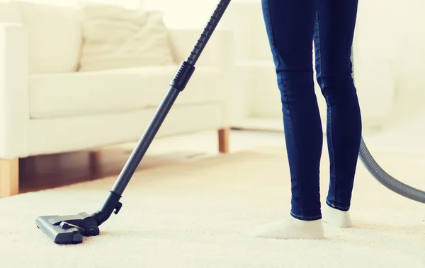 Close up of woman legs with vacuum cleaner at home — Stock Photo, Image