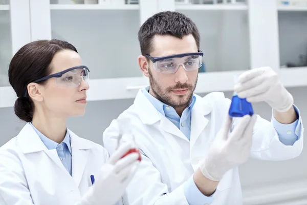 Jóvenes científicos haciendo pruebas o investigaciones en laboratorio —  Fotos de Stock