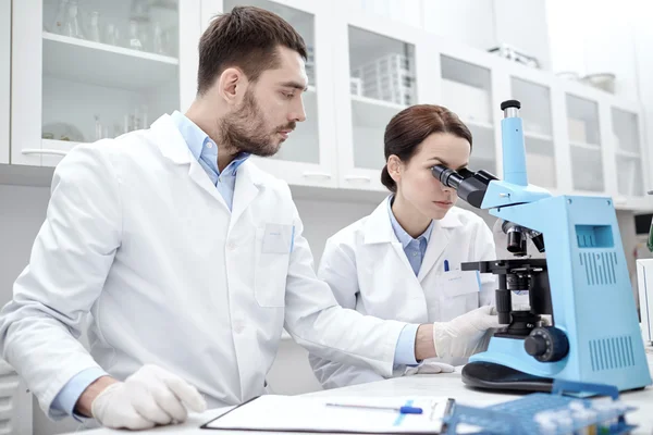 Jóvenes científicos haciendo pruebas o investigaciones en laboratorio —  Fotos de Stock