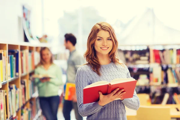 Happy student dívka nebo žena s knihou v knihovně — Stock fotografie