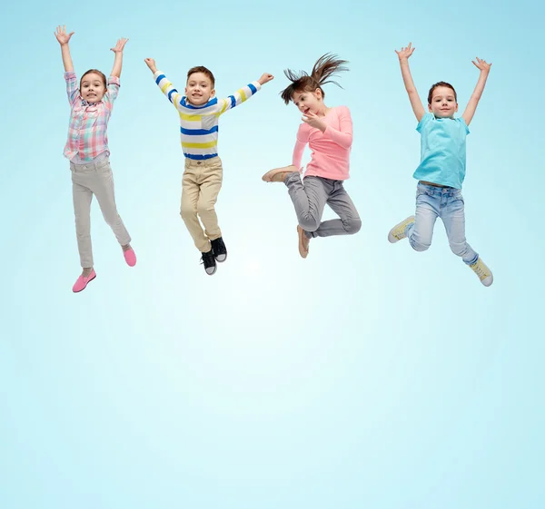 Niños pequeños y felices saltando en el aire sobre azul —  Fotos de Stock