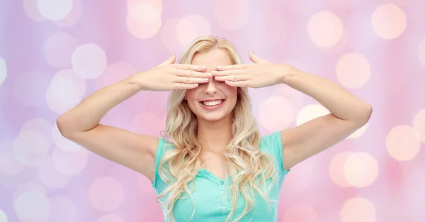 Lächelnde junge Frau oder Teenagerin, die ihre Augen bedeckt — Stockfoto