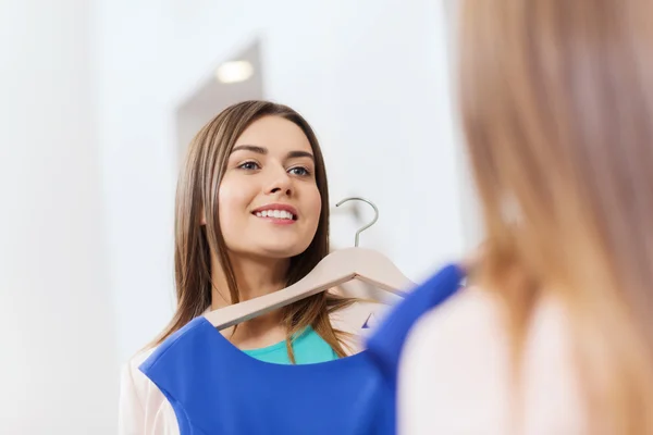 Щаслива жінка з одягом у дзеркалі магазину одягу — стокове фото