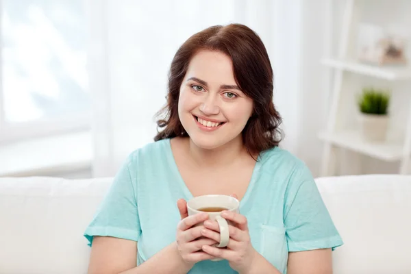 Mujer feliz más tamaño con taza de té en casa —  Fotos de Stock