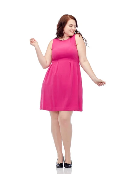 Šťastný mladý plus velikost ženy tančí v růžových šatech — Stock fotografie