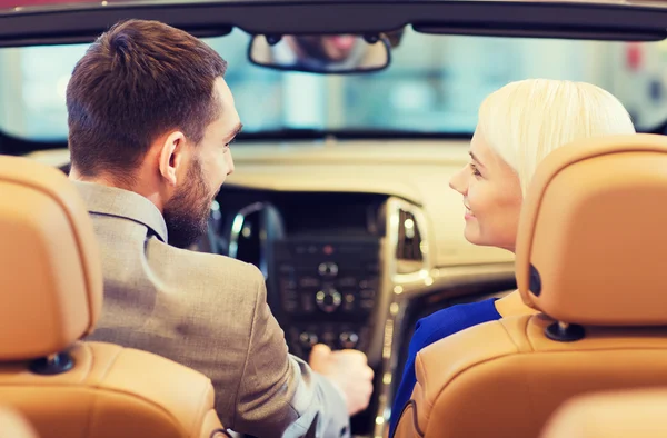 Glückliches Paar im Auto auf der Auto Show oder im Salon — Stockfoto