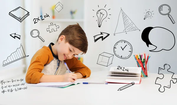 Estudante sorrindo menino escrevendo para notebook em casa — Fotografia de Stock
