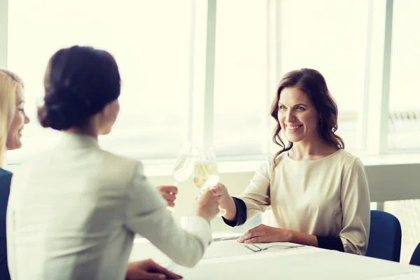 Happy women drinking champagne at restaurant — Stock Photo, Image