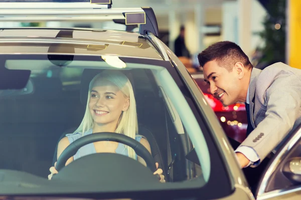 Glad kvinna med Bilhandlare i auto visa eller salong — Stockfoto
