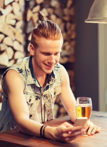 Šťastný muž s smartphone, pití piva na baru — Stock fotografie