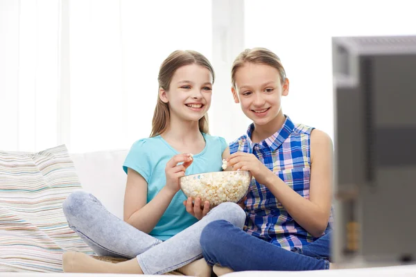 Meninas felizes com pipocas assistindo tv em casa — Fotografia de Stock