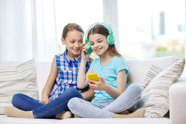 Meninas felizes com smartphone e fones de ouvido — Fotografia de Stock