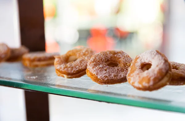 Close up de donuts açucarados na prateleira vitrine — Fotografia de Stock