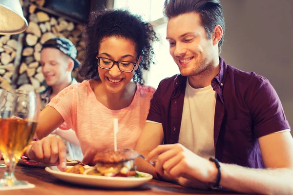 Happy vänner äta och dricka i baren eller på puben — Stockfoto