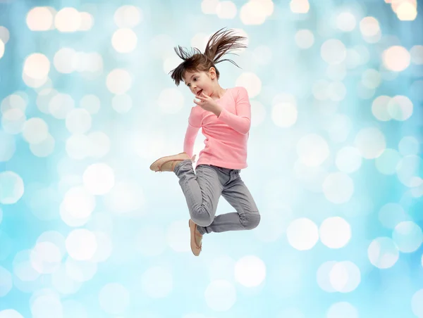 Gelukkig klein meisje in de lucht springen over blauwe lichten — Stockfoto