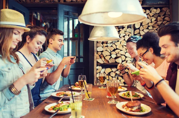 Ευτυχείς φίλοι με smartphones εικονίζεται τροφίμων — Φωτογραφία Αρχείου