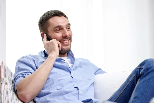 Glücklicher Mann, der zu Hause mit dem Smartphone telefoniert — Stockfoto