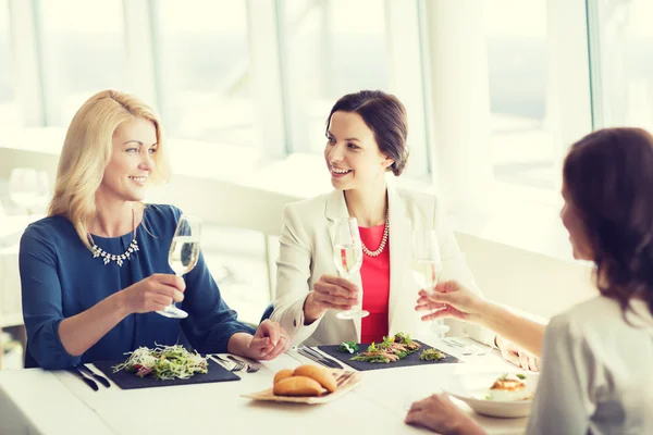 Glada kvinnor dricka champagne på restaurang — Stockfoto