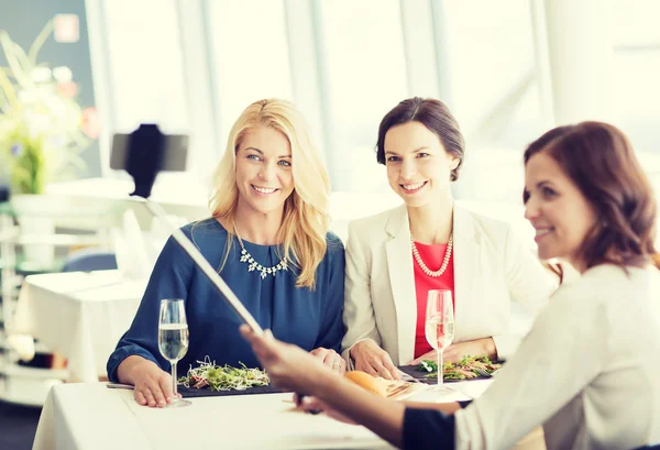 Women with smartphone taking selfie at restaurant — Stock Photo, Image