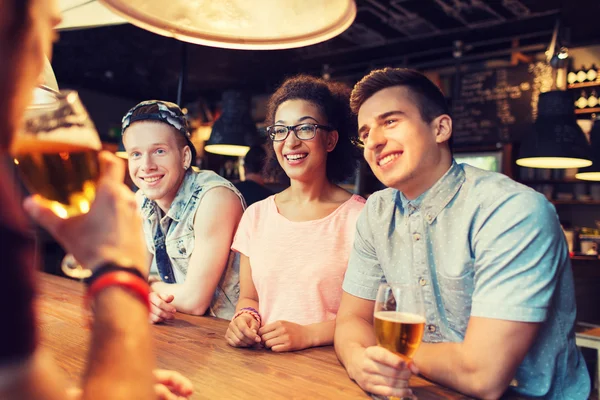 Glückliche Freunde, die Bier trinken und sich an der Bar unterhalten — Stockfoto