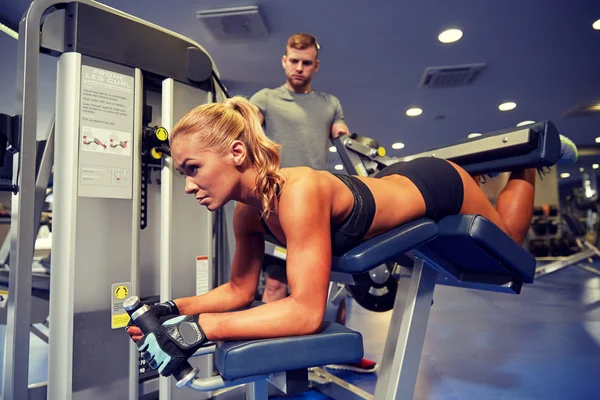 Hombres y mujeres flexionando los músculos en la máquina de gimnasio —  Fotos de Stock