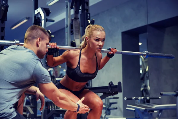 Mann und Frau mit angespannten Muskeln im Fitnessstudio — Stockfoto