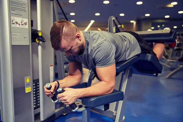 男子屈腿肌肉在健身房机器上的应用 — 图库照片