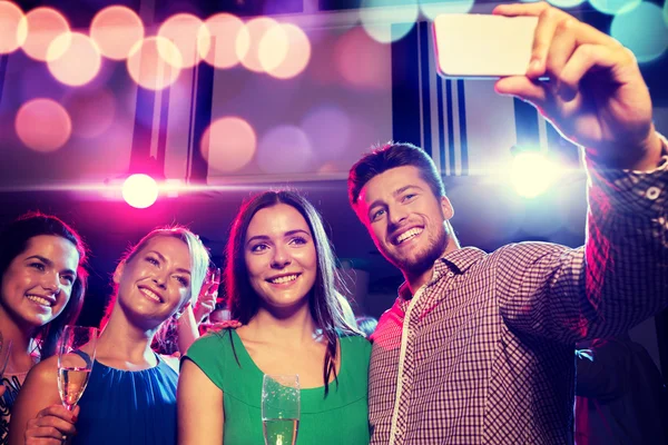 Friends with glasses and smartphone in club — Stock Photo, Image