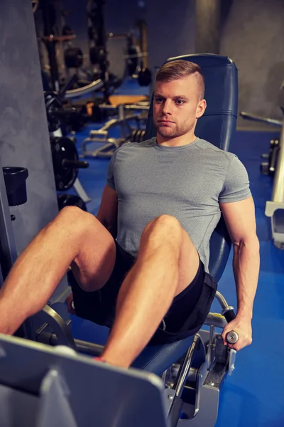 Homme flexion des muscles des jambes sur la machine de gymnase — Photo