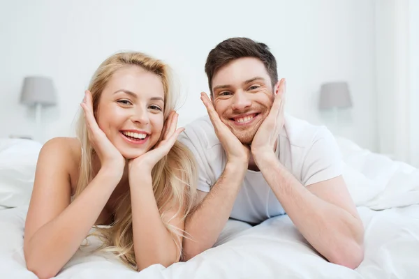 Feliz pareja acostada en la cama en casa —  Fotos de Stock