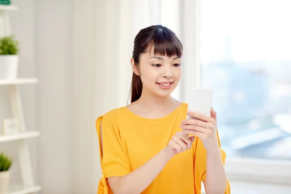 Happy asijské žena s smartphone doma — Stock fotografie